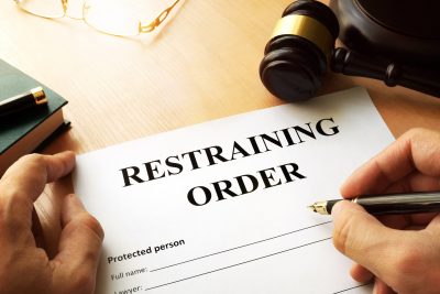 Man working on a document that says "restraining order"